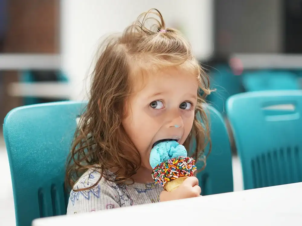Home 60 Cute baby enjoying a scoop of ice cream at Keds Ice Cream